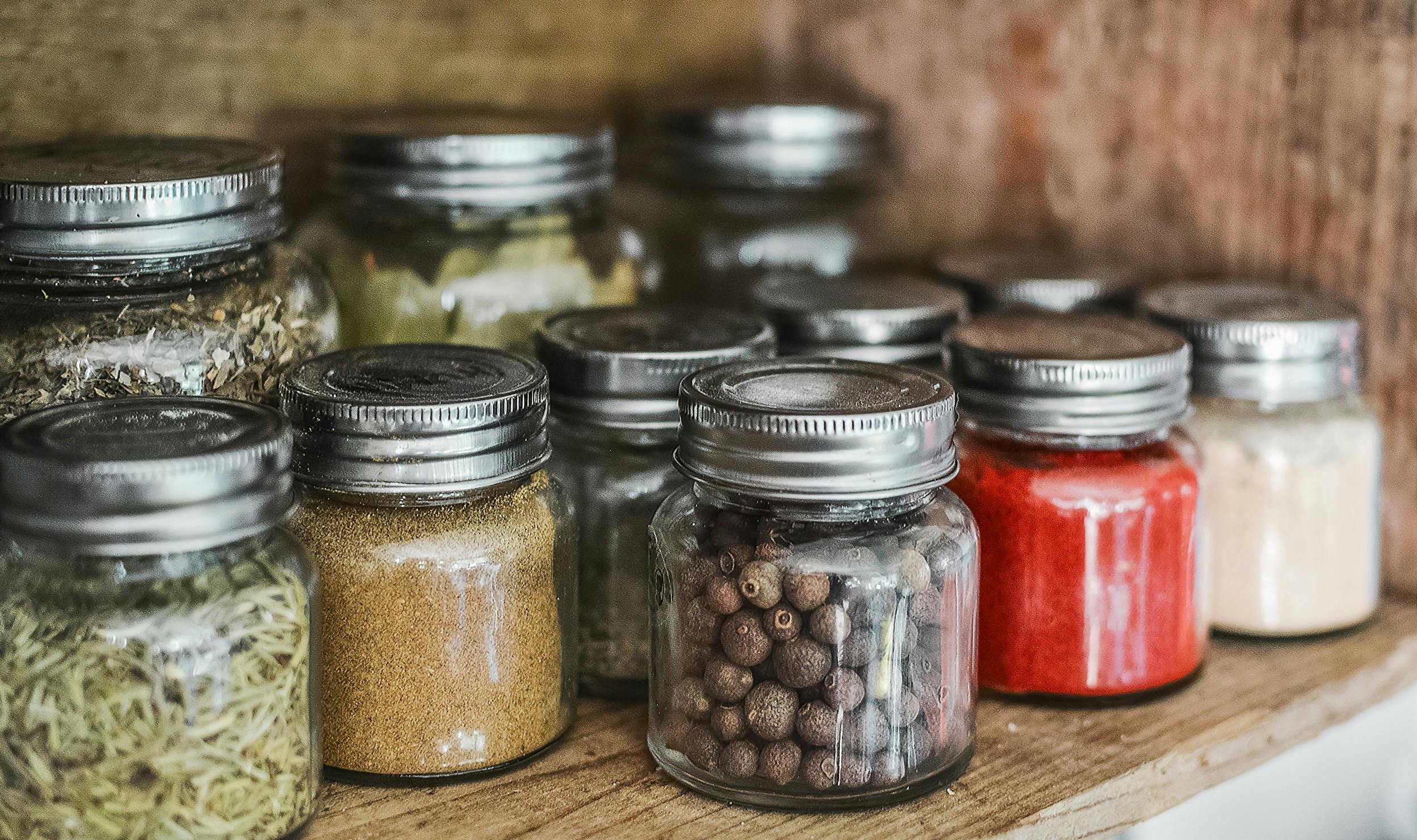 Spice jars on wooden shelf